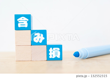 含み損の概念を表す青色ブロックと白背景のシンプルな金融イメージ。 132552315