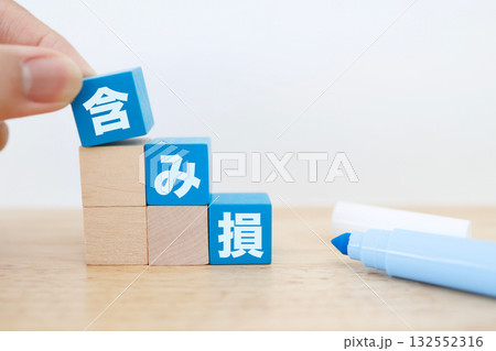 含み損の概念を表す青色ブロックと白背景のシンプルな金融イメージ。 132552316