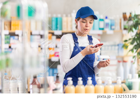 Builder woman in pharmacy scans QR code on antifungal ointment Builder woman in pharmacy scans QR code on antifungal ointment 132553190