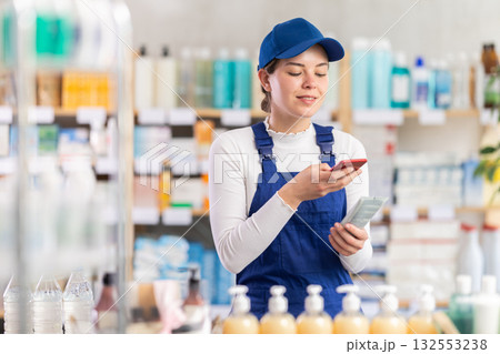 Builder woman in pharmacy scans QR code on cream 132553238