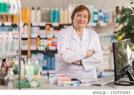 Professional elderly female pharmacist searches for information about medicines on Internet 132553261