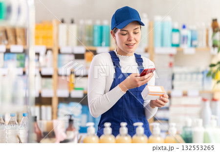Builder woman in pharmacy scans QR code on tablet pills Builder woman in pharmacy scans QR code on tablet pills 132553265