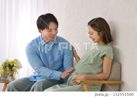 ソファに座ってくつろぐ若い夫婦　妊婦さん 132553500
