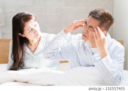 起きてベッドの上で会話をする夫婦 起きてベッドの上で会話をする夫婦 132557403