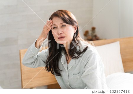 起きてベッドの上で悪寒を訴える女性 132557418