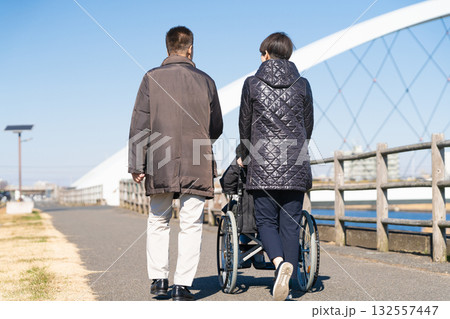 車椅子を押して散策をする親子 車椅子を押して散策をする親子 132557447