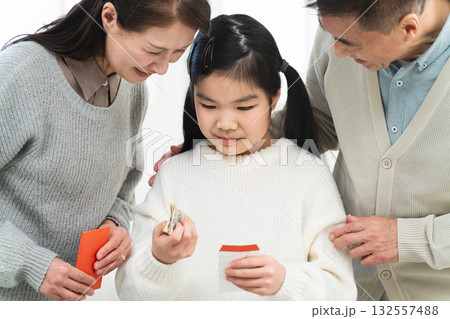 祖父と祖母からお年玉をもらう女の子 132557488