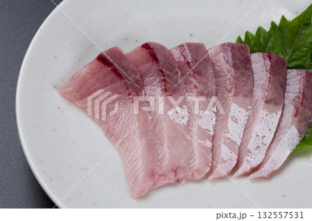 皿に盛られたブリのお刺身 黒背景 132557531