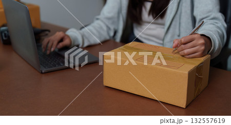 E-commerce: Individual labeling packages while using a laptop 132557619