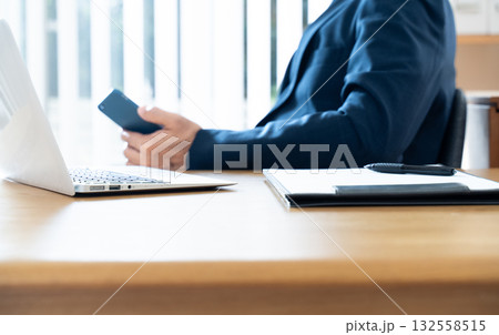 スマホを操作するビジネスマンの手元 スマホを操作するビジネスマンの手元 132558515