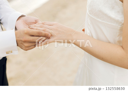 女性の指に指輪をはめる男性の手 132558630