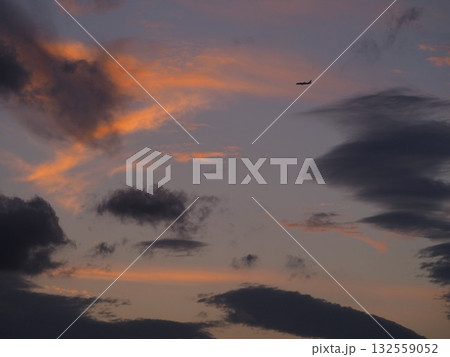 美しい夕焼けの空を飛ぶ飛行機 132559052