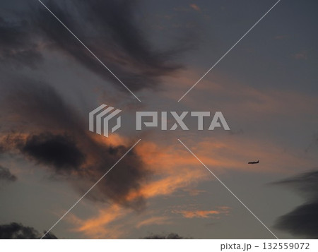 美しい夕焼けの空を飛ぶ飛行機 132559072