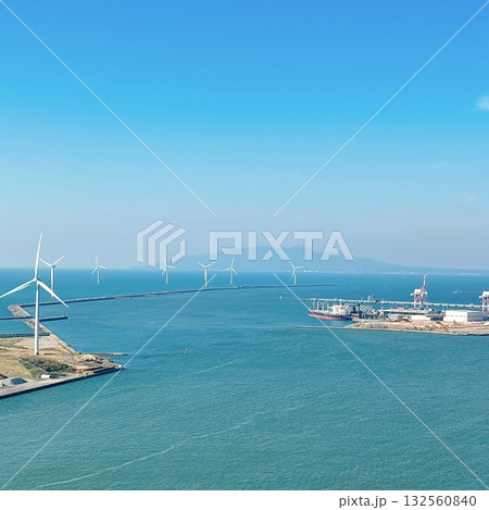 青空の下に並ぶ風力発電の風車と港の風景 青空の下に並ぶ風力発電の風車と港の風景 132560840