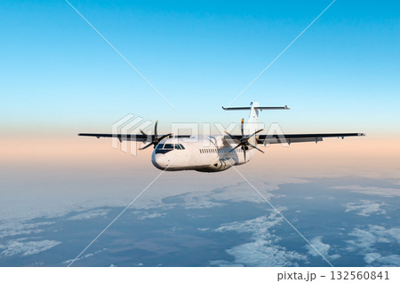 White passenger turboprop plane flying in the morning air above the clouds White passenger turboprop plane flying in the morning air above the clouds 132560841