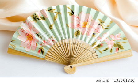 Delicate pastel hand fan with pink floral patterns evokes vintage elegance and springtime charm in soft focus setting Delicate pastel hand fan with pink floral patterns evokes vintage elegance and springtime charm in soft focus setting 132561816