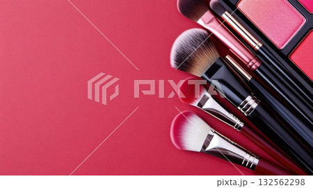Makeup artist tools arranged elegantly in deep red shades with brushes, palettes, and swatches highlighting modern beauty trends 132562298