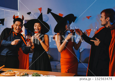 Joyful office Halloween party with coworkers in costumes, celebrating with drinks and laughter, fostering teamwork and festive spirit Joyful office Halloween party with coworkers in costumes, celebrating with drinks and laughter, fostering teamwork and festive spirit 132563474