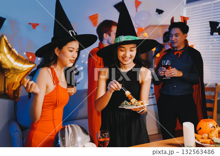 Joyful office Halloween party with coworkers in costumes, celebrating with drinks and laughter, fostering teamwork and festive spirit 132563486