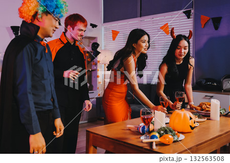 Joyful office Halloween party with coworkers in costumes, celebrating with drinks and laughter, fostering teamwork and festive spirit 132563508