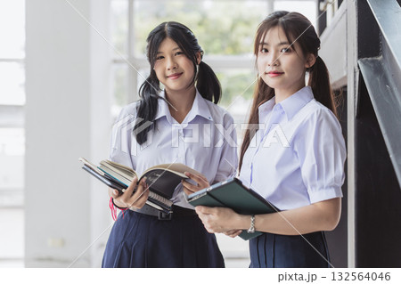 Portrait smart students women teen in uniform standing together at modern school campus indoor. 132564046