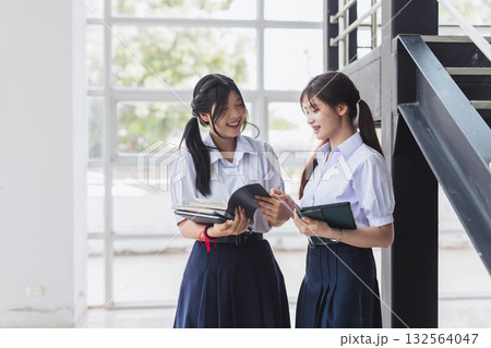 Smart students women teen in uniform standing together at modern school campus indoor. Smart students women teen in uniform standing together at modern school campus indoor. 132564047