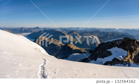 Climbers ascend the snowy slopes of Piz Palu in the Bernina Range, surrounded by stunning alpine views. Summer offers a perfect hiking experience across the glacier landscape. Climbers ascend the snowy slopes of Piz Palu in the Bernina Range, surrounded by stunning alpine views. Summer offers a perfect hiking experience across the glacier landscape. 132564162