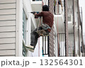 Exterior repair worker rappel down using ropes to repair leaking cement walls residential buildings. 132564301