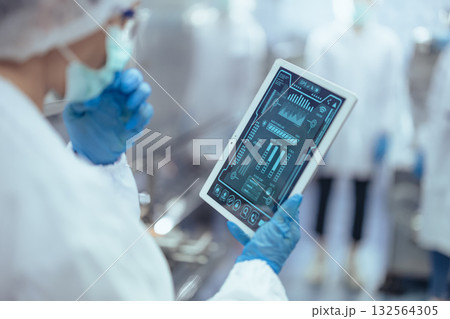 technician worker using tablet in food and drinks factory monitor control inspecting production line 132564305