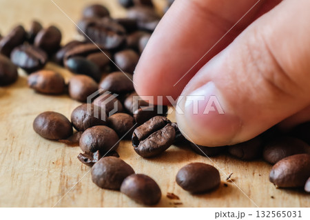 Close-up of Hand Picking Roasted Coffee. 132565031