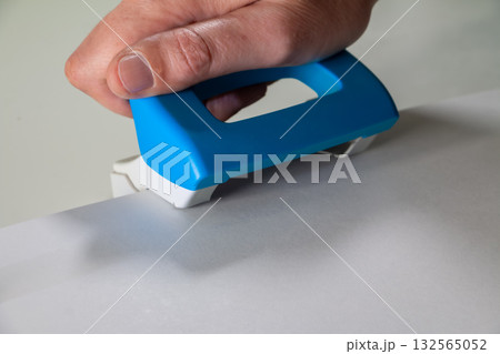 Hand Using Paper Cutter to Trim White Sheet - Office or School Tool Hand Using Paper Cutter to Trim White Sheet - Office or School Tool 132565052