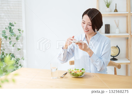 サラダを食べる女性・スマホ サラダを食べる女性・スマホ 132568275