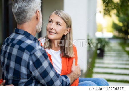 Mature couple sitting next to each other and feeling in love Mature couple sitting next to each other and feeling in love 132568474