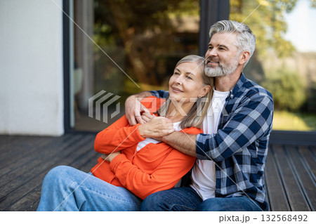 Gray-haired bearded man hugging woman tenderly and both feeling relaxed 132568492