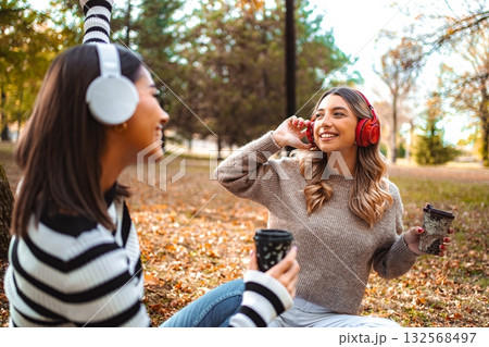 Enjoying autumn vibes and friendship with music and coffee in the park Enjoying autumn vibes and friendship with music and coffee in the park 132568497