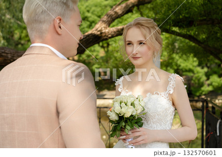 Couple exchanges vows in a serene outdoor setting during a wedding ceremony Couple exchanges vows in a serene outdoor setting during a wedding ceremony 132570601