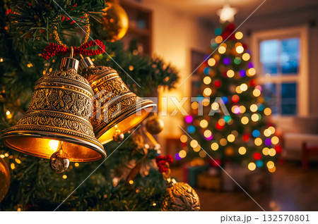 Closeup of gloden Christmas bells and illuminated Christmas tree. Closeup of gloden Christmas bells and illuminated Christmas tree. 132570801