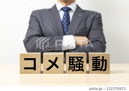 「コメ騒動」と書かれたブロックと腕組みをするビジネスマン 「コメ騒動」と書かれたブロックと腕組みをするビジネスマン 132570823
