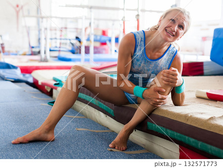 Injured female gymnast suffering from knee pain after bad landing Injured female gymnast suffering from knee pain after bad landing 132571773