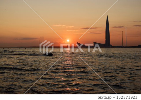 A breathtakingly stunning sunset over the water alongside a magnificent city skyline A breathtakingly stunning sunset over the water alongside a magnificent city skyline 132571923