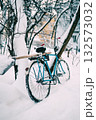 Blue Bicycle Leaning Against Snowy Tree in Quiet Winter Yard Exterior Scene 132573032