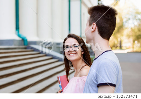 Couple of students walking to classes early in the morning. Happy students in love heading to university together Couple of students walking to classes early in the morning. Happy students in love heading to university together 132573471