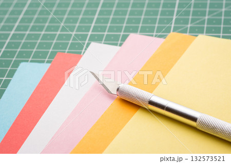Scalpel on a stack of colorful papers 132573521