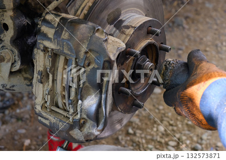 A mechanic works on a brake system at a garage. A mechanic works on a brake system at a garage. 132573871