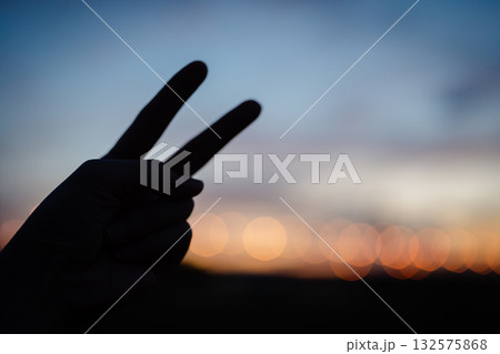 夕焼けをバックに指で番号を表す　2 132575868