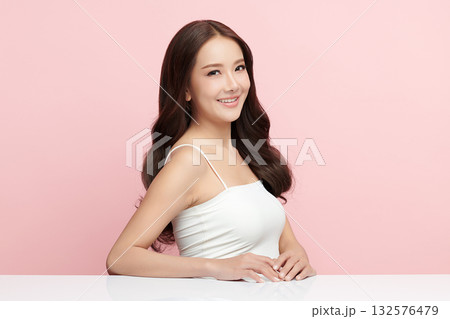 A beautiful young Asian woman with clean, fresh skin against a pink background. Skincare, facial treatment, cosmetology, beauty, and spa. An elegant portrait of an Asian woman. A beautiful young Asian woman with clean, fresh skin against a pink background. Skincare, facial treatment, cosmetology, beauty, and spa. An elegant portrait of an Asian woman. 132576479
