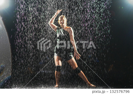 Contemporary woman dancer posing in rain water on black background. Female artist performer dancing with expression. Modern ballerina dancing in darkness. Passion dance in dark. Flexibility balance Contemporary woman dancer posing in rain water on black background. Female artist performer dancing with expression. Modern ballerina dancing in darkness. Passion dance in dark. Flexibility balance 132576796