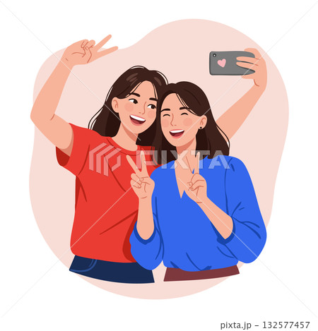 Two young women taking selfie with smartphone and making peace signs cheerful moment 132577457