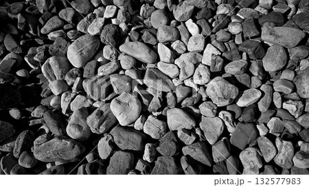 texture of a natural assortment of pebbles and river stones in warm earth tones, ideal for landscaping, garden borders, pathways, or decorative rock surfaces 132577983