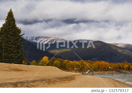 Autumn Beach with Mountains and Dramatic Clouds in the Background 132578317